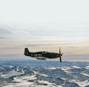 Paul Draper guides Jack Roush’s P-51B “Old Crow” over the Cascade Mountains on the way to Auburn, California for Anderson’s 100th birthday party as seen from Ray Fowler’s view in the cockpit of Jim Hagedorn’s P-51D “Old Crow.”