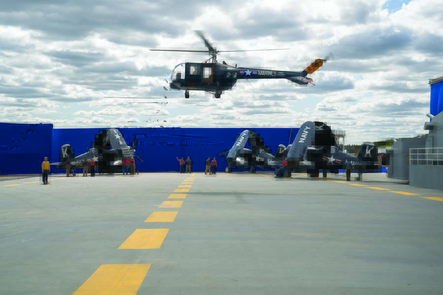 Alex Anduze hovers the world’s only airworthy Sikorsky HO5S-1 above the mock-up flight deck of the USS Leyte on-set at Bulloch County Airport. Anduze’s HO5S-1 represents the HO3S-1 that USMC Lt. Charlie Ward rescued LTJG Hudner with. Below, left to right, are Erickson Aircraft Museum’s F4U-7, CAF Airbase Georgia’s FG-1D, and Planes of Fame’s F4U-1. (Photo by Eli Adé/Columbia Pictures)